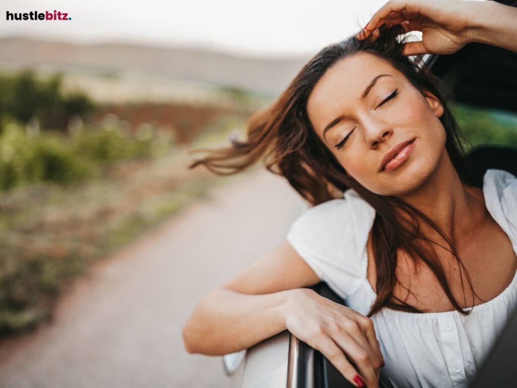 Woman enjoying wind through car window.